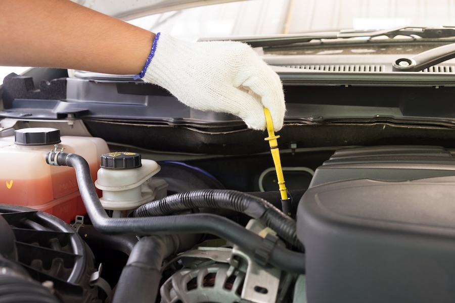 A closeup image of a hand testing a car's transmission fluid